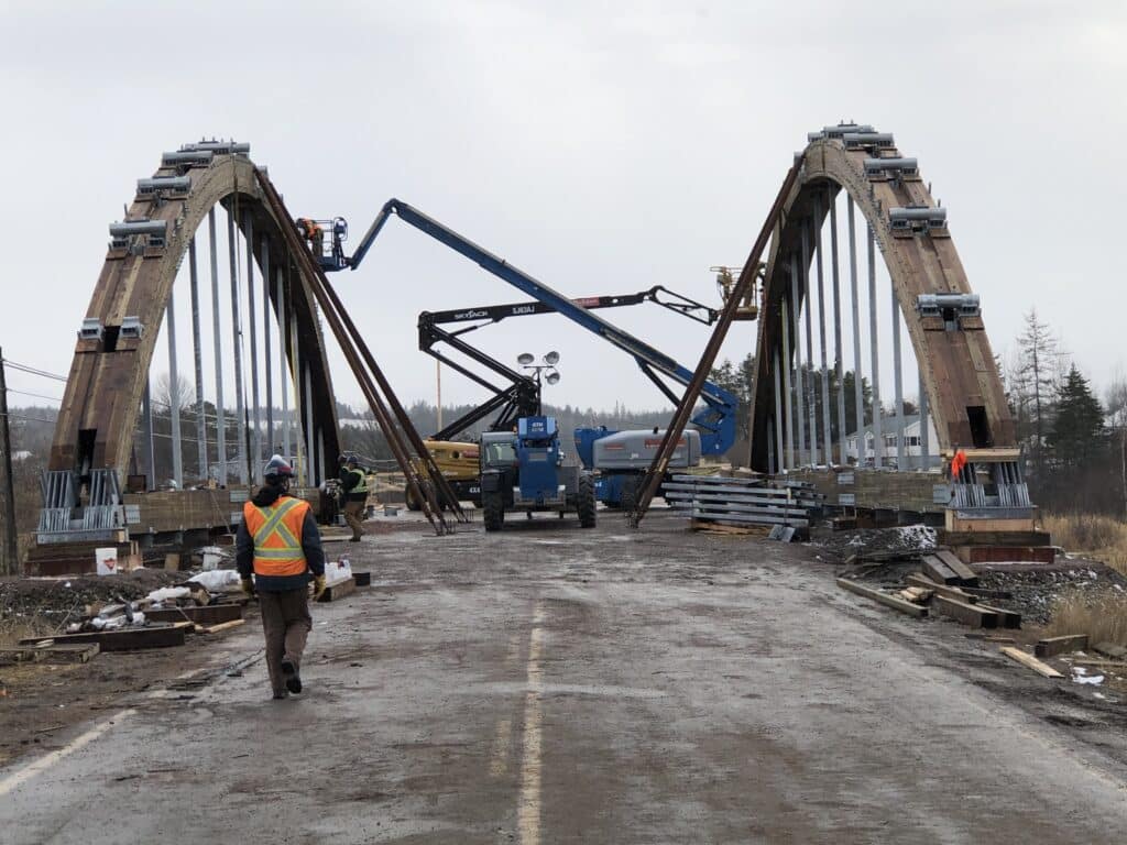 Crew working from an aerial platform beneath the Roger Bacon Bridge arch